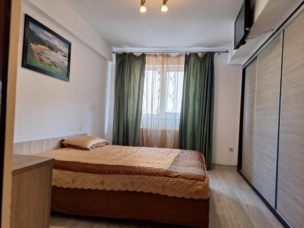 una camera con letto e finestra con tende verdi di The Secret Studios 3 a Craiova