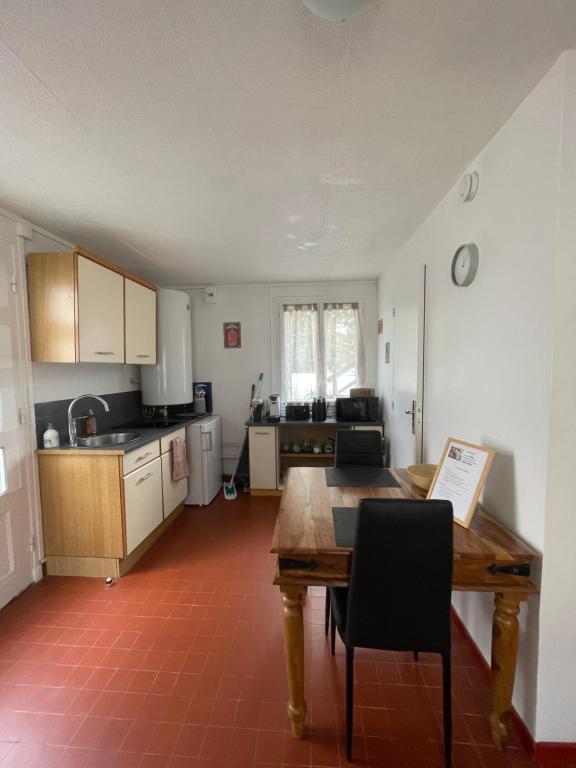 una cucina con un tavolo di legno e una sala da pranzo di La clé des champs a Éguzon-Chantôme