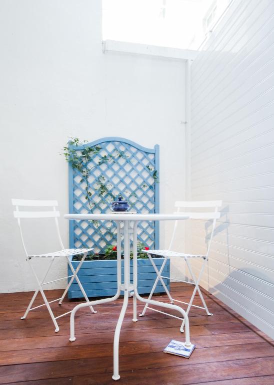 a white table and two chairs on a porch at Les Loges des Chalets in Toulouse