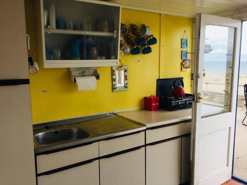 a kitchen with a sink and a counter top at Comfy Holiday Home & Beach Hut in Sutton on Sea