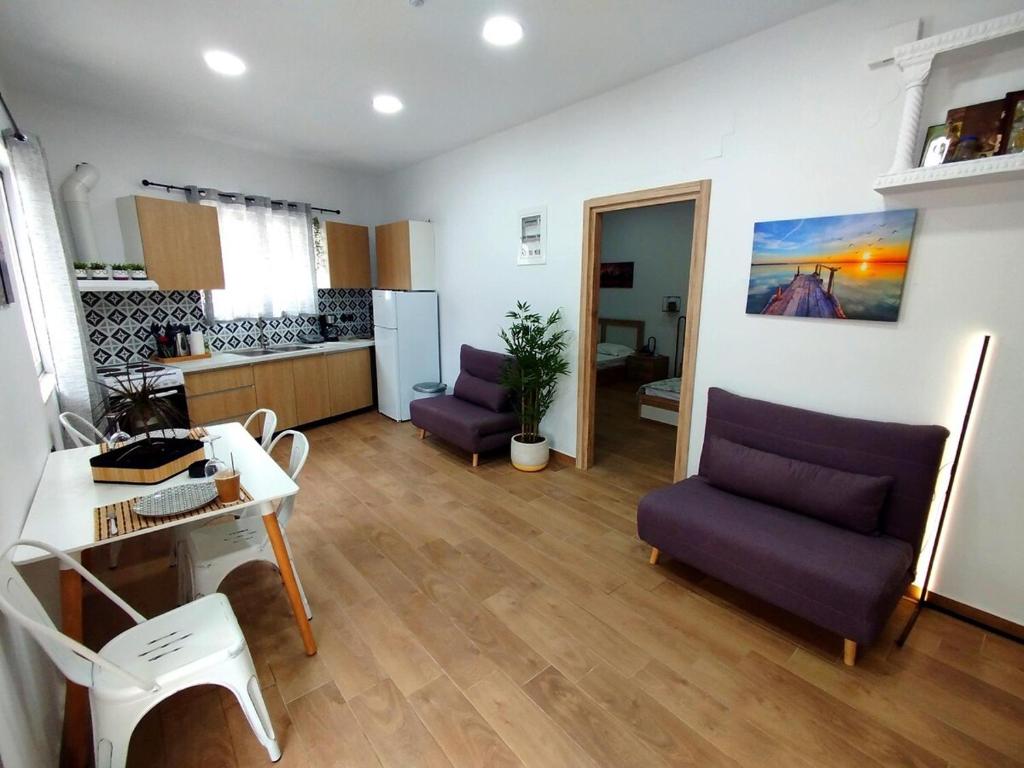 a living room with a purple couch and a kitchen at Leonidio Downtown Haven in Leonidion