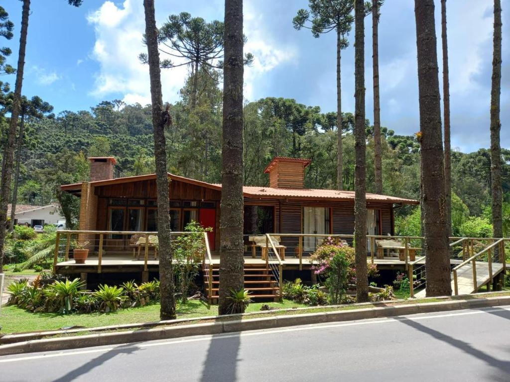 a house on the side of a road with palm trees at Recanto Bellagio in Campos do Jordão