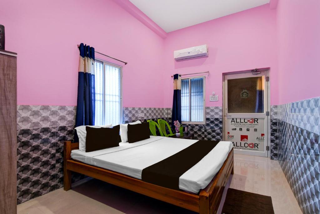 a bedroom with a bed in a pink room at OYO Flagship Hotel O Mo Kudia in Puri