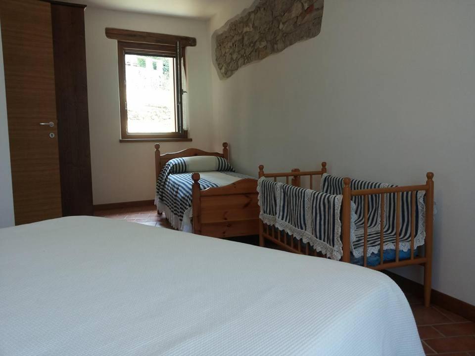 1 dormitorio con 1 cama y 2 cunas en Alloggi Valle di Soffumbergo, en Valle