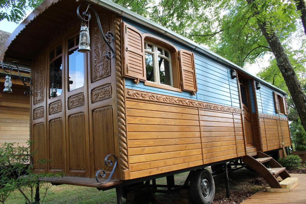 a wooden train car on display in a yard at Roulotte Zelena Hora in Cadalen