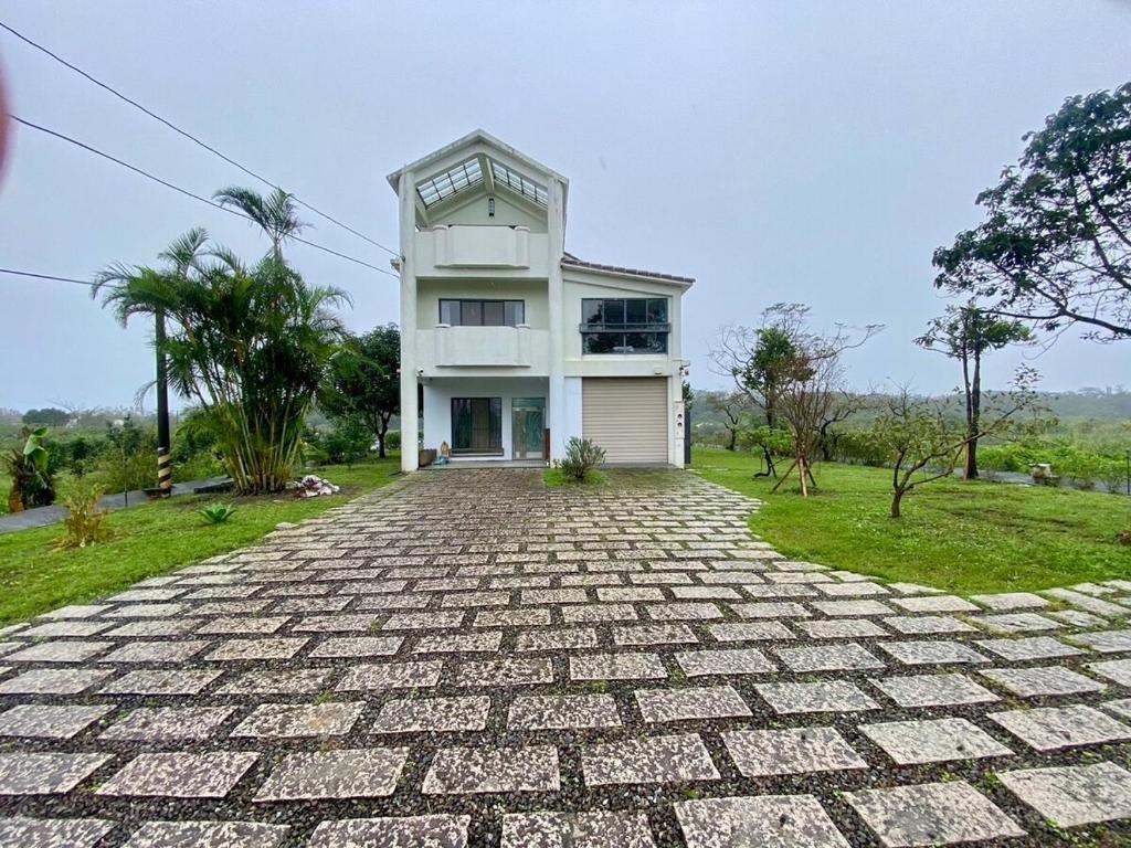 Una gran casa blanca con una entrada de ladrillo en Mushin Club 沐心智苑會館, en Wujie