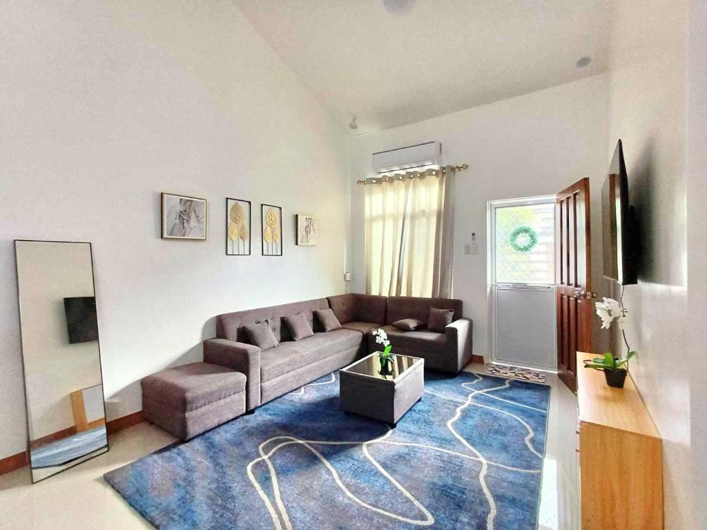 una sala de estar con un sofá y una alfombra en MJs Residence, en General Santos