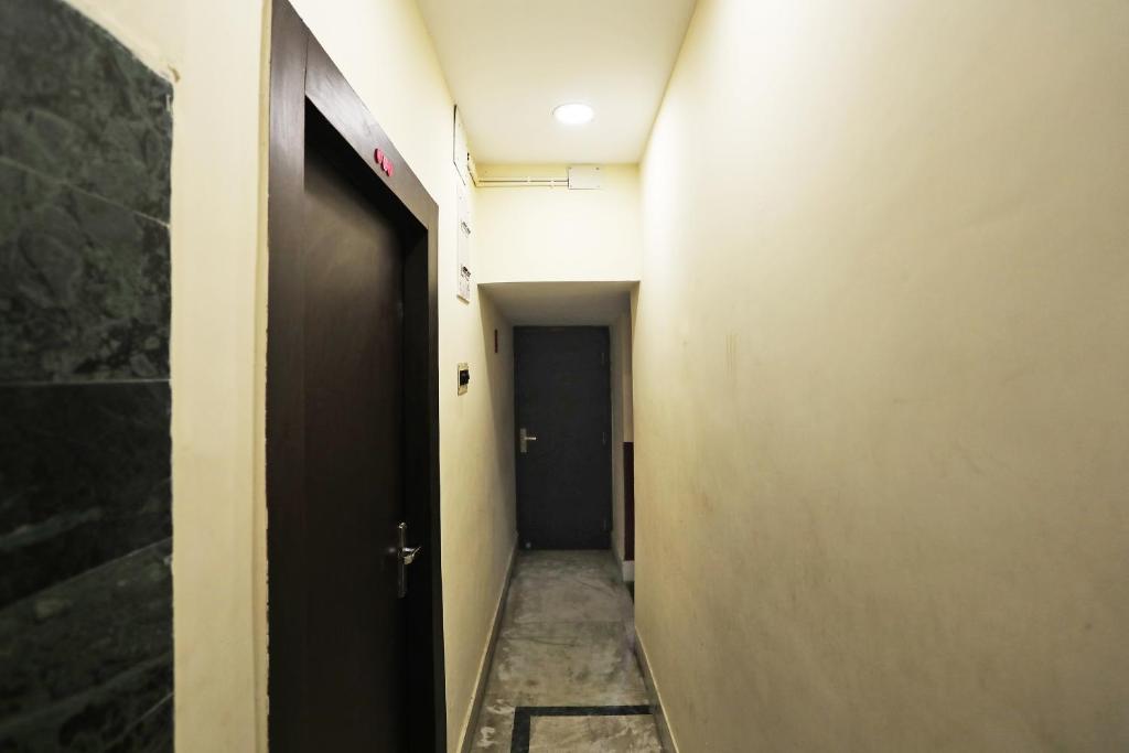 a hallway with a black door and a black hallway sidx sidx at Hotel O Chinar in kolkata