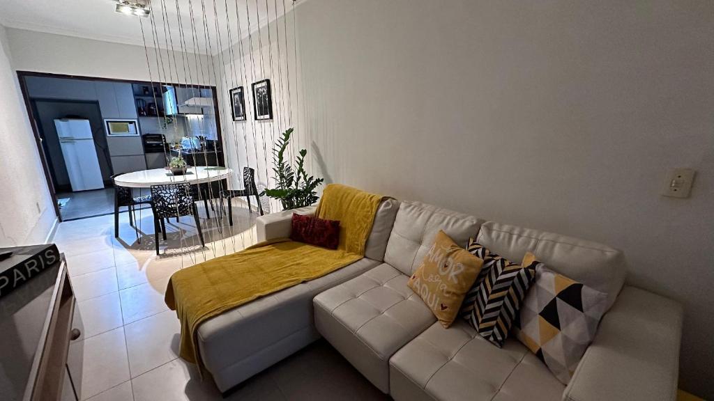 a living room with a white couch and a table at Quartos Casa do Rosa Casa Compartilada in São João da Boa Vista