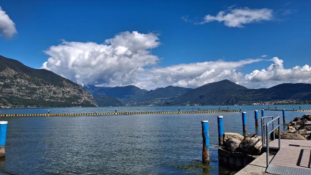 a large body of water with a pier and mountains at Cavallo Blu in Clusane sul Lago