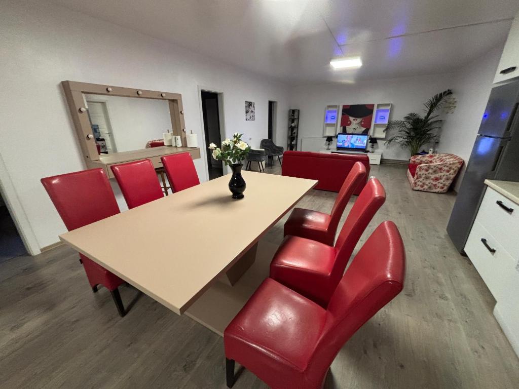 a conference room with a table and red chairs at Bob Residence- Chic Penthouse in Cluj-Napoca