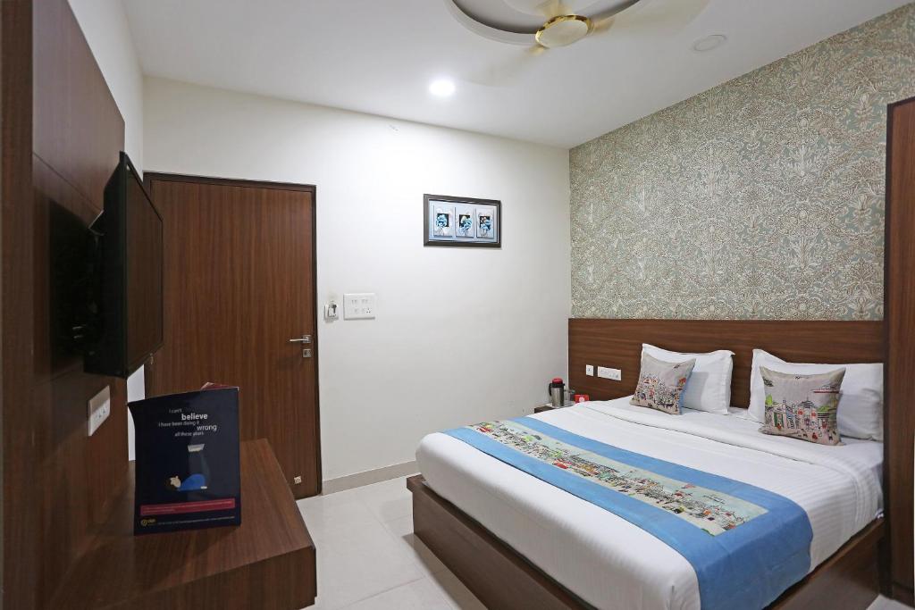 a bedroom with a bed and a flat screen tv at Super Capital O Swastika in Jaipur