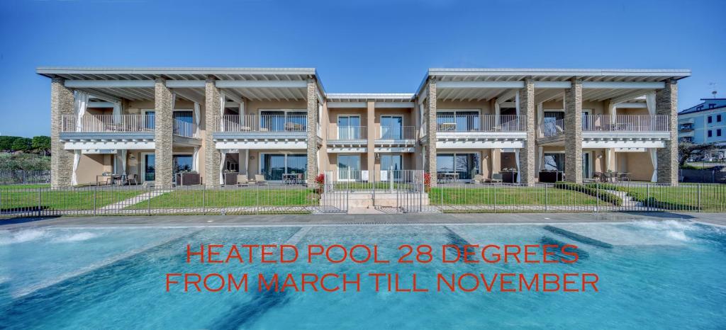un bâtiment avec une piscine devant dans l'établissement La Giolosa Gardapartments, à Moniga del Garda