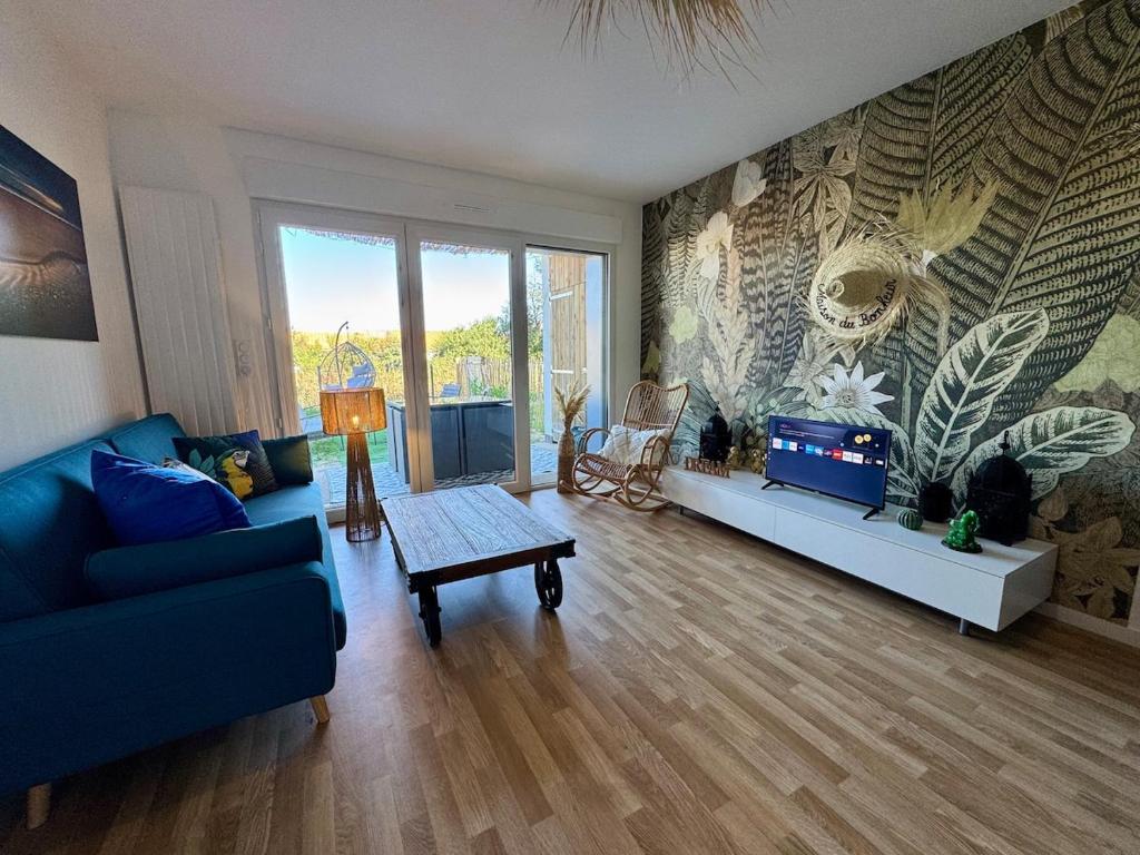 a living room with a blue couch and a tv at T3 Lumineux avec super Terrasse in Saint-Gilles-Croix-de-Vie