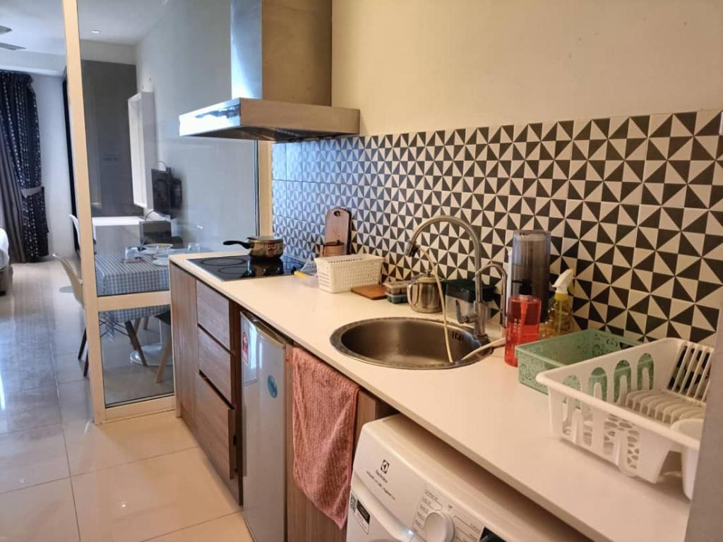 a kitchen with a sink and a geometric wall at The Grand Residence in Dhaka