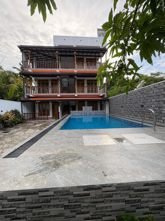 a house with a swimming pool in front of a building at Villa Rosella in Ahangama