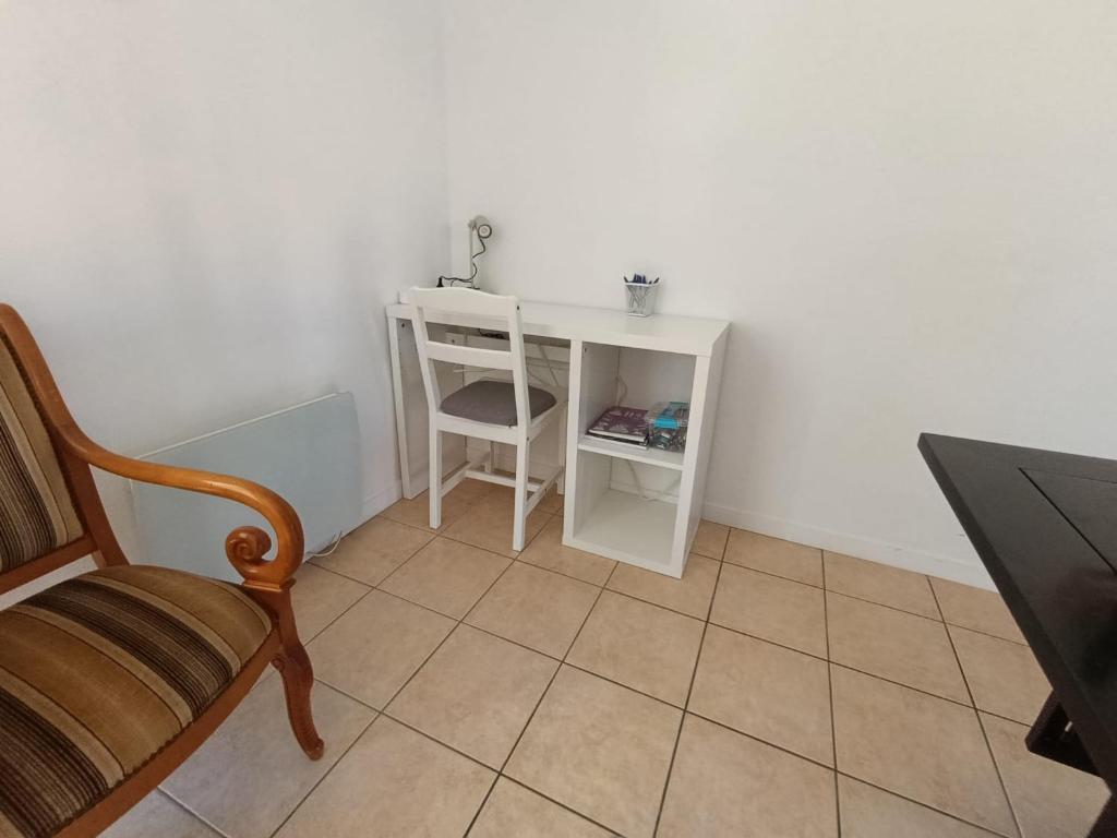 a small white desk with a chair in a room at Location 4-6 personnes in Grayan-et-lʼHôpital