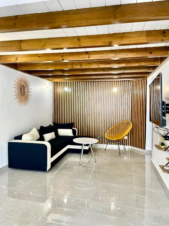 a living room with a couch and a table at Nid Créole in Vieux-Habitants