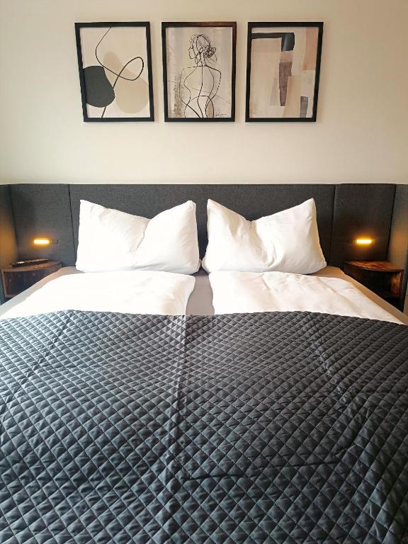 a bedroom with a bed with four pictures on the wall at PanoramaLoft Warendorf in Warendorf