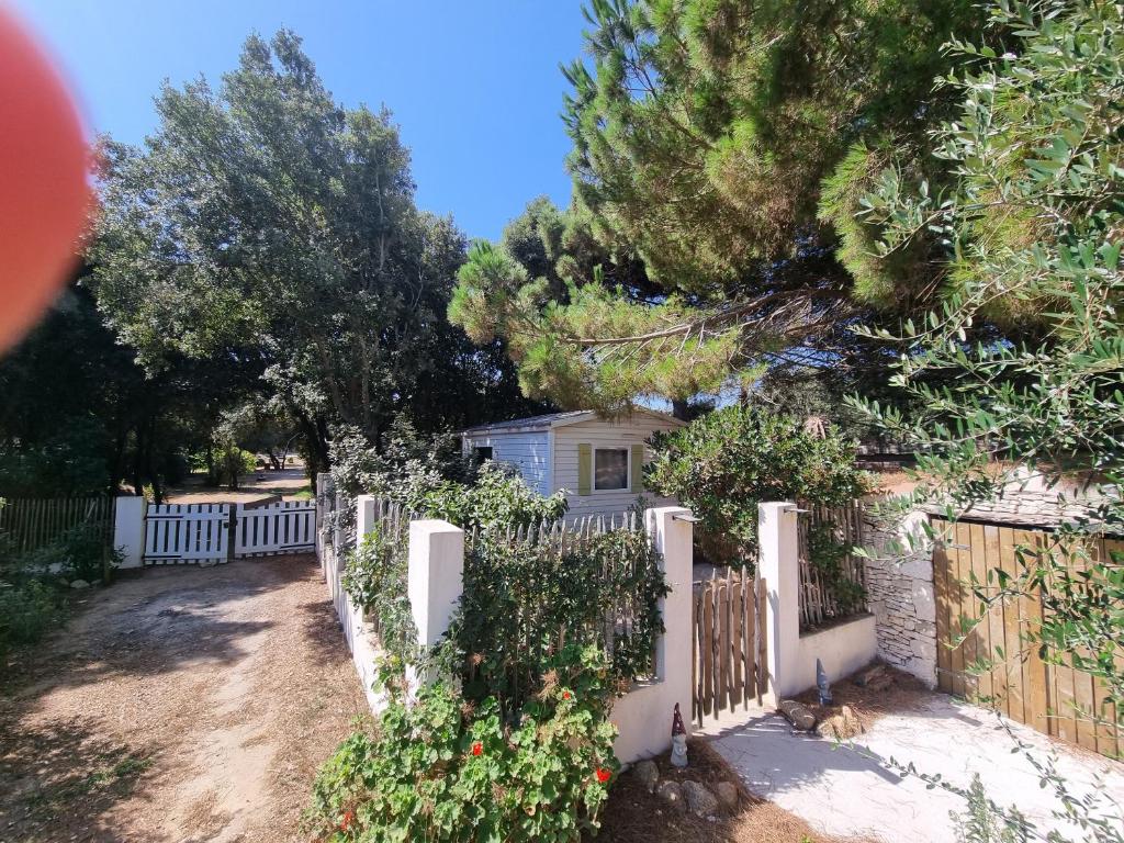 a white fence in front of a house at Logement dans terrain privé et familiale in Bonifacio