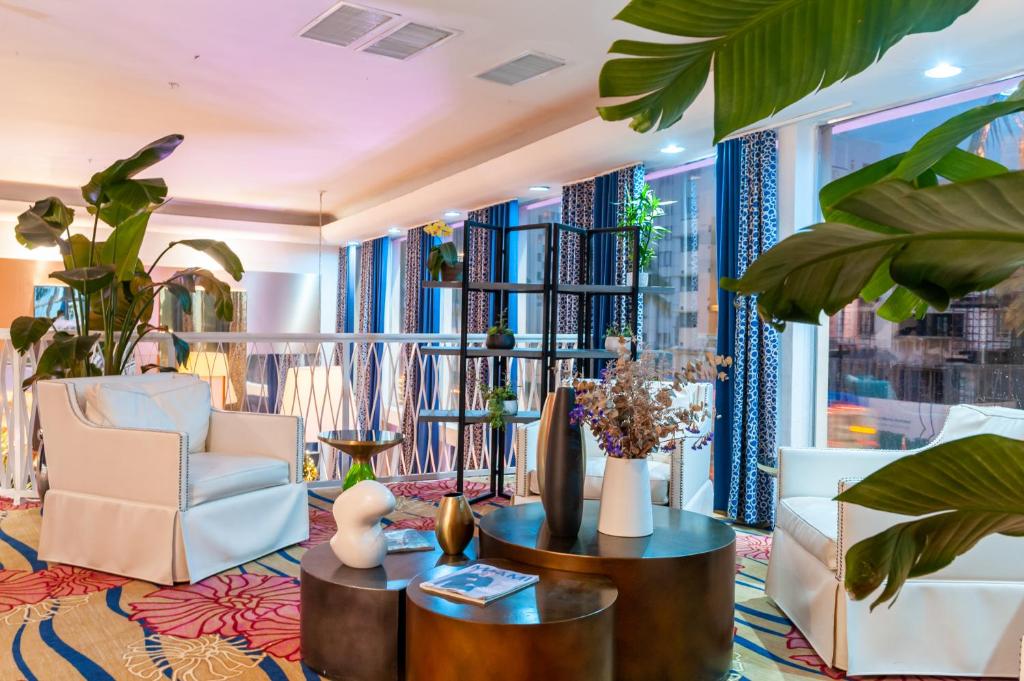 a lobby with a chair and tables and plants at Catalina Hotel & Beach Club in Miami Beach