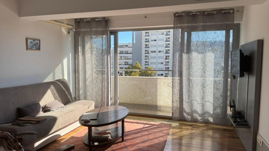 a living room with a couch and a large window at Апартаменты Ирина М in Bar