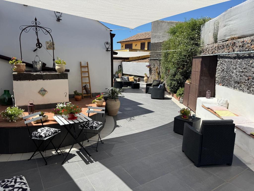 un patio avec une table et des chaises sur un patio dans l'établissement Casa Vacanze Vicolo Palaù, à Trecastagni