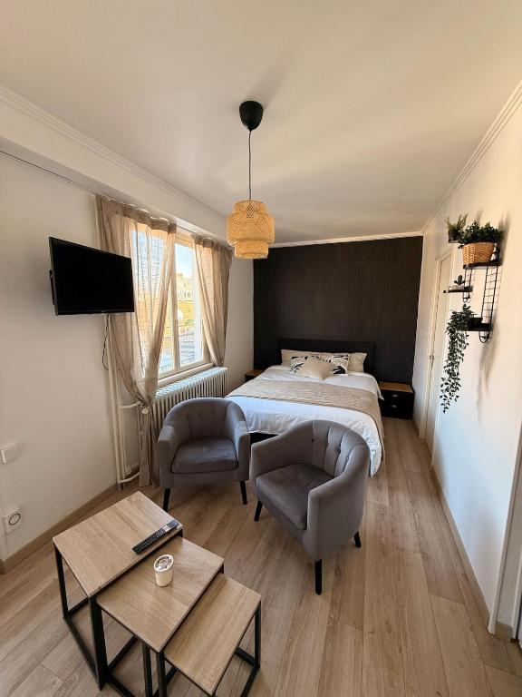 ein Schlafzimmer mit einem Bett und zwei Stühlen in der Unterkunft Studio dans le cœur de Mulhouse in Mulhouse