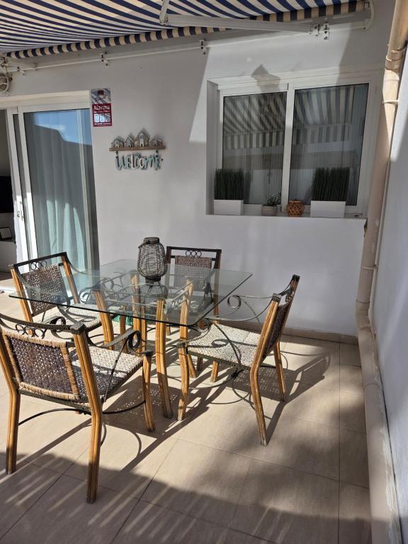 un tavolo in vetro e sedie su un patio di Las Dos Orillas a Costa Calma