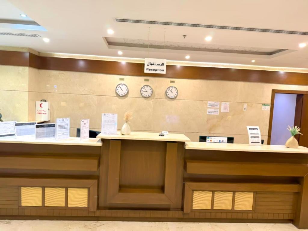 a hotel lobby with clocks on the wall at Asfar Plaza Hotel & Apartments in Riyadh