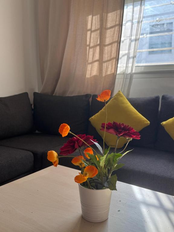 un jarrón con flores en una mesa delante de un sofá en Fleury, en Fez