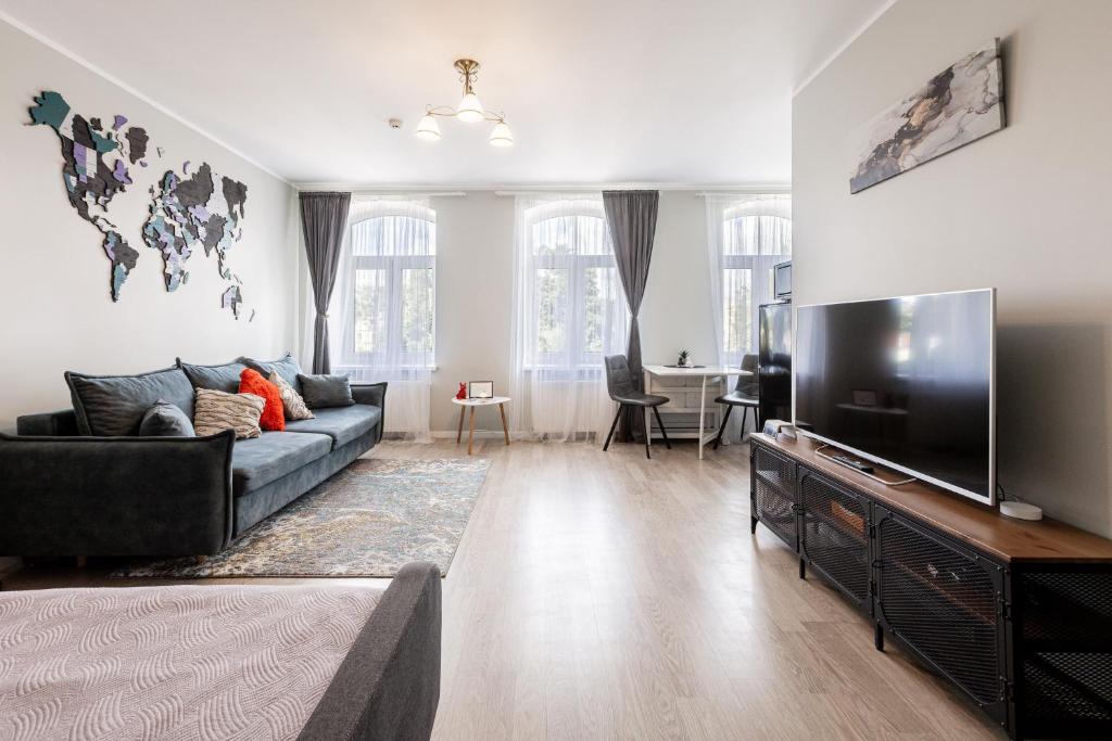 a living room with a couch and a flat screen tv at Modern studio in Siena Tirgus in Rīga
