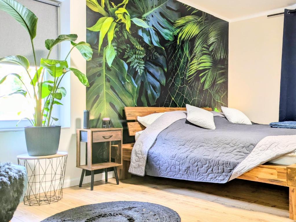 a bedroom with a bed with a mural of plants at Sonnenterrasse & 2 King-Size DZ - Citynah & ruhig in Berlin