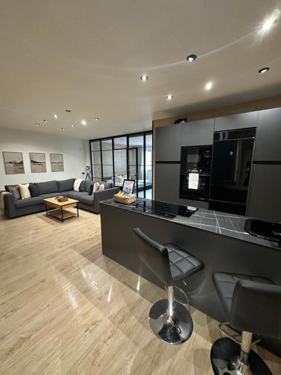 a kitchen and living room with a counter and a bar at Urban Loft Rosal - parking privado in Oviedo