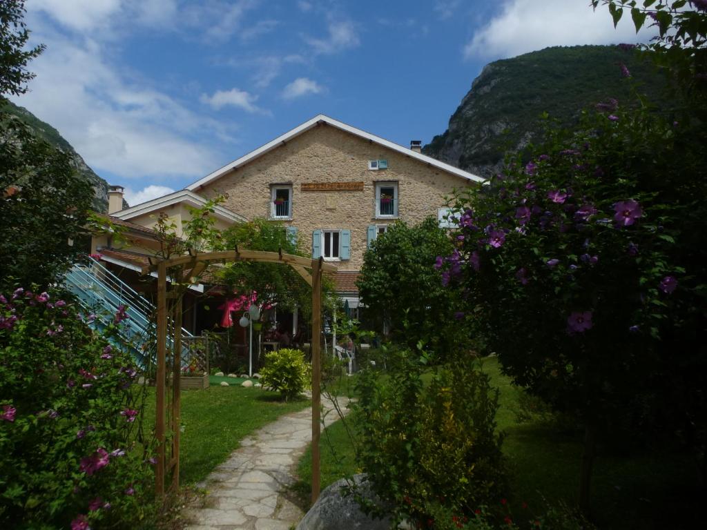 a house with a garden with flowers in front of it at La petite auberge de niaux in Niaux