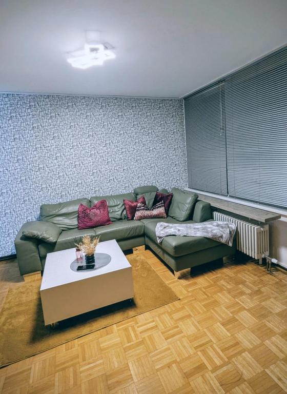 ein Wohnzimmer mit einer grünen Couch und einem Tisch in der Unterkunft MiMo 24 in Köln