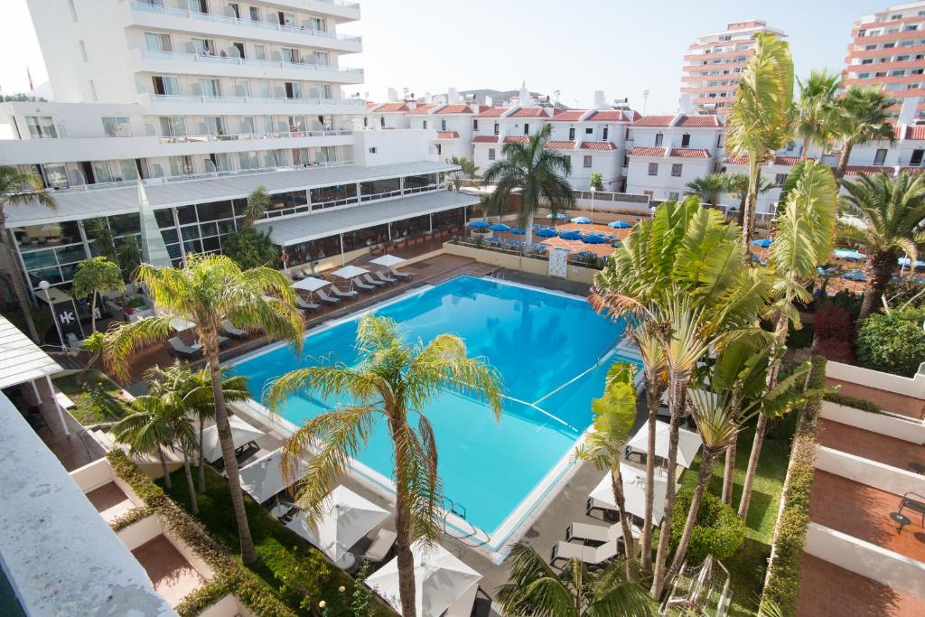 a large swimming pool in a city with palm trees at Catalonia Oro Negro in Playa de las Americas