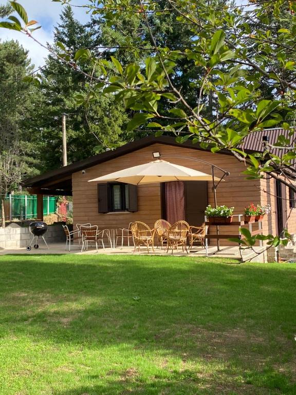 a house with a table and chairs and an umbrella at La Villetta Trepidò in Casa Pasquale