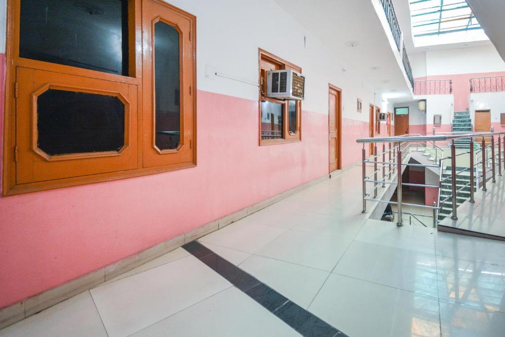 a hallway in a school with a pink wall at SPOT ON 36686 Hotel Om Shanti Palace in Chandīgarh