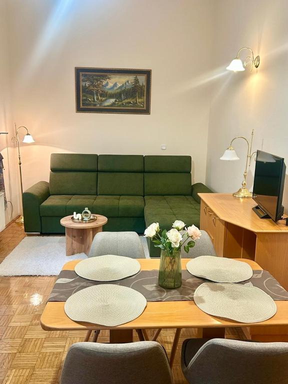 a living room with a green couch and a table at Ana Marija Apartment - Vila Golf in Rogaška Slatina