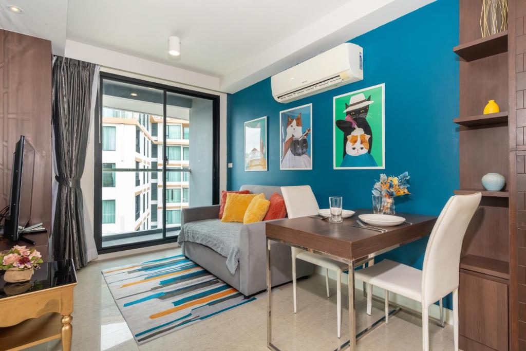 ein Wohnzimmer mit einer blauen Wand in der Unterkunft 1 Bedroom Apartment - The Aristo Resort by HCR in Ban Lum Fuang