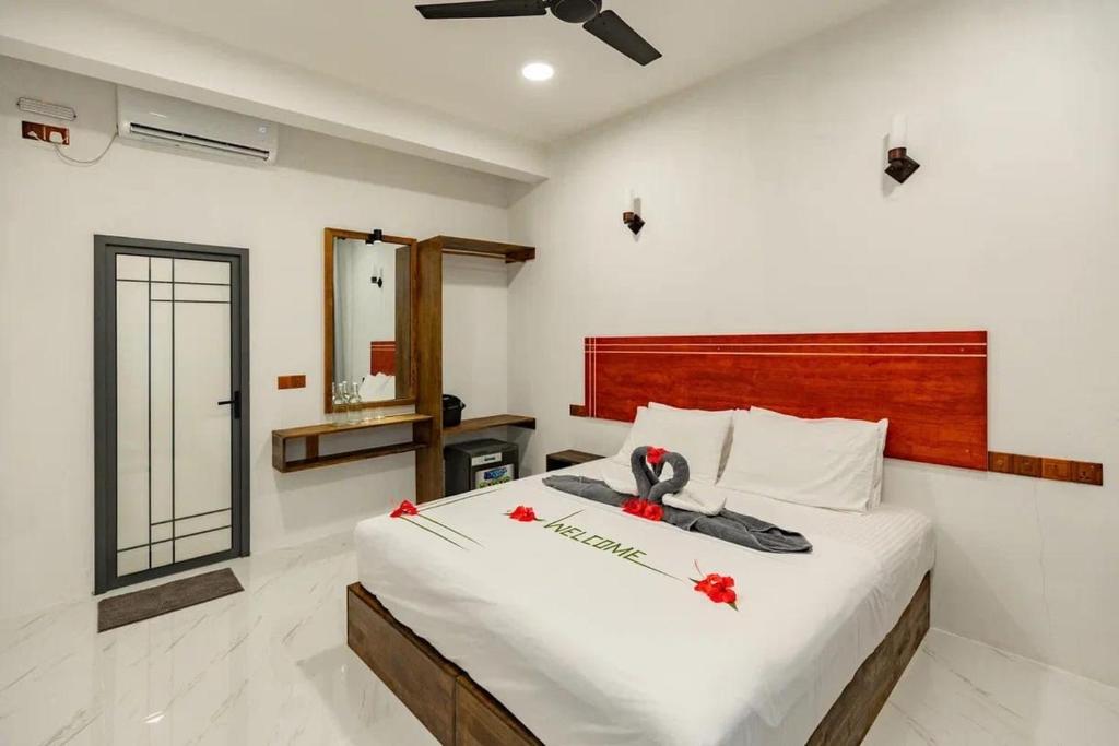 a bedroom with a large bed with red flowers on it at Oak Thoddoo in Toddu Atoll