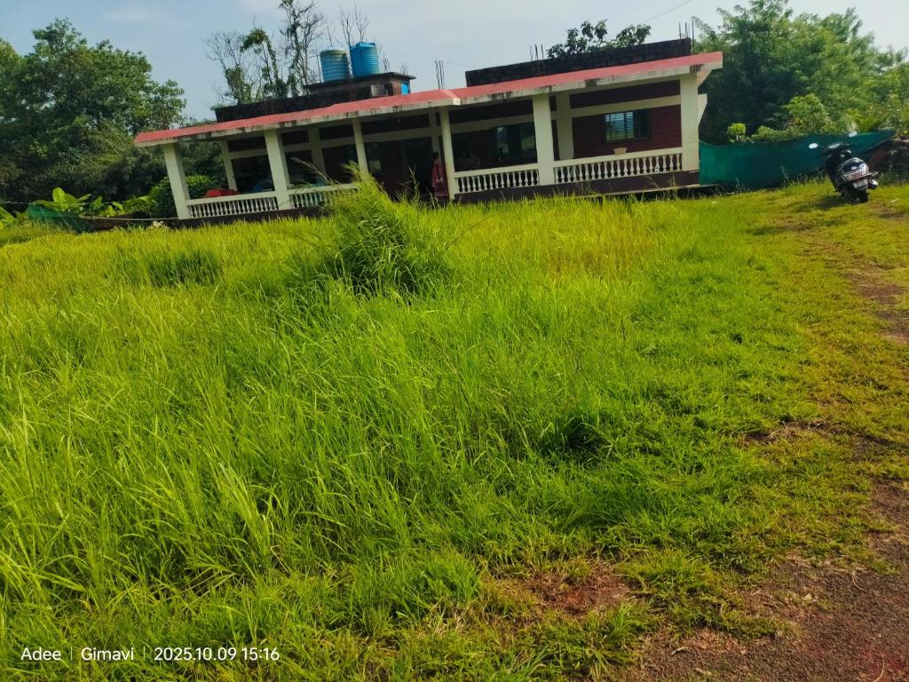 een huis in het midden van een grasveld bij Sukhad Home Stay in Gimvi