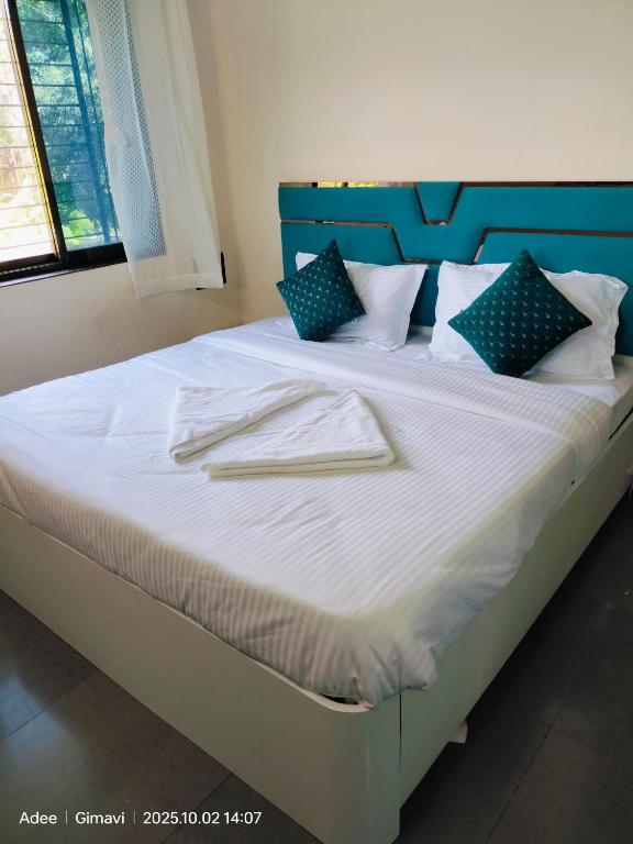 a bed with two napkins on top of it at Sukhad Home Stay in Gimvi