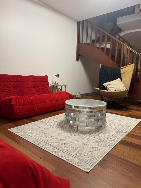 a living room with a red couch and a table at Les Hauts de la Baie in Fort-de-France