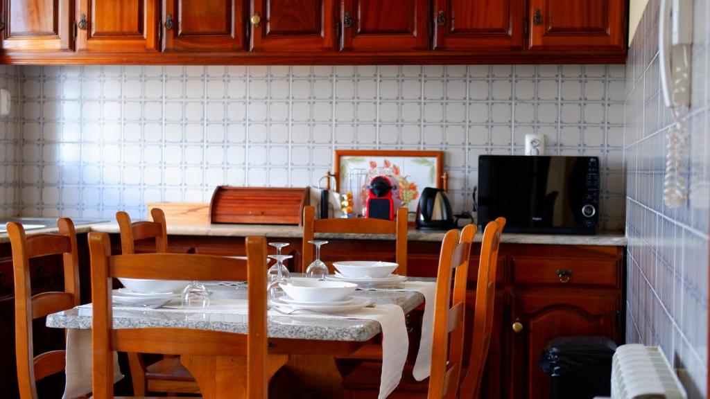 a kitchen with a table with chairs and a television at Casa Outeiro 99 in Paredes de Coura