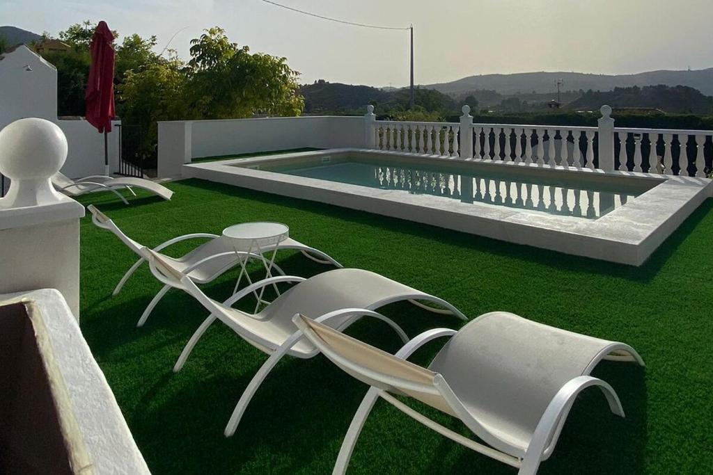 a yard with two chairs and a swimming pool at La Pollera in Cehegín