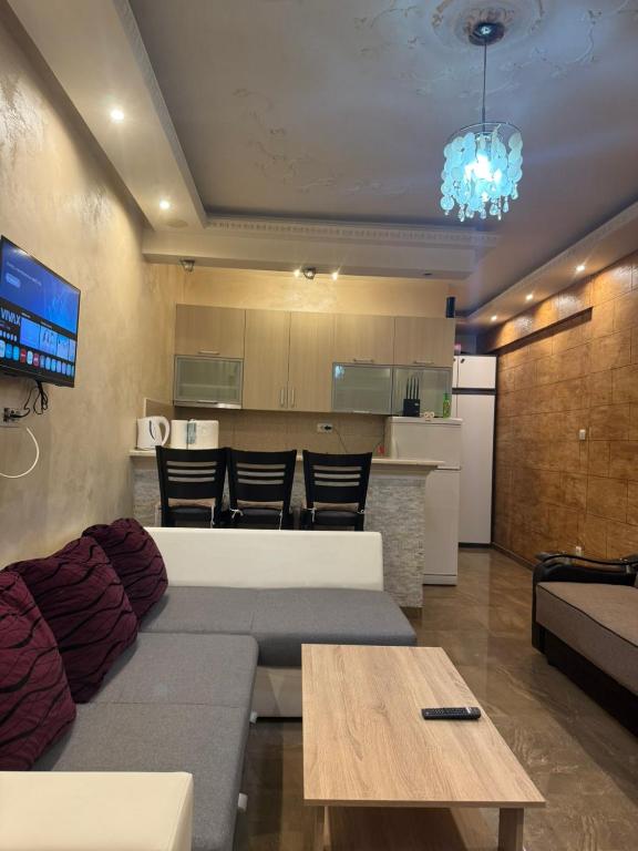 a living room with a couch and a table and a kitchen at Apartman Martina 3 in Rafailovici
