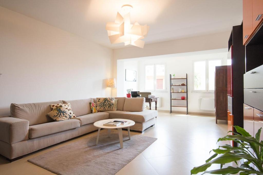 a living room with a couch and a table at Appartamento e terrazza vista mare con giardino in Finale Ligure