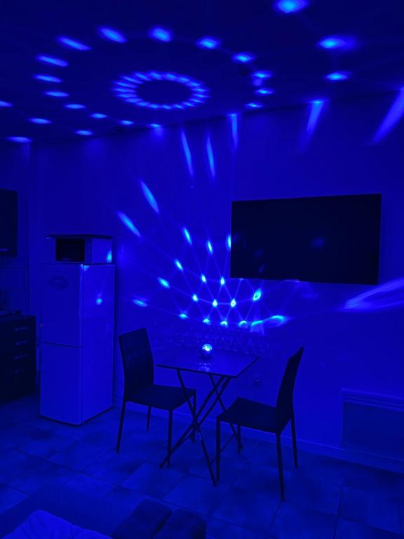 a blue room with a table and chairs and a tv at Flandre 01 in Roubaix